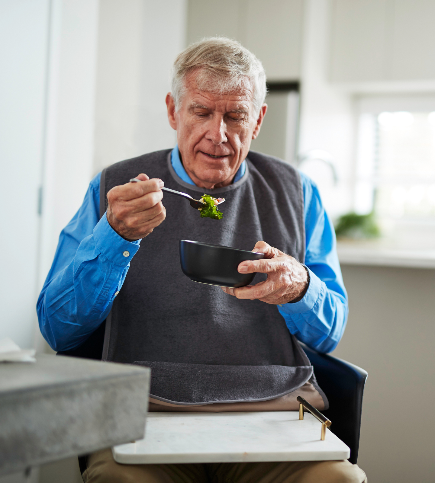 Adult dining gracefully with fabric tray bib
